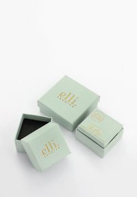 Cutii de cadou de culoare verde mentă, cu un finisaj mat, prezentând imprimeuri aurii. Include o cutie pătrată deschisă și o altă cutie dreptunghiulară mai mică.