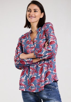 Floral blouse in blue, featuring red and white leaf patterns, with a v-neck and long sleeves. Soft fabric with a relaxed fit.