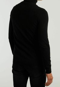 Schwarzer Rollkragenpullover mit gerippten Schulterdetails und strukturiertem Finish. Figurbetontes Design mit langen Ärmeln, ideal zum Layering.