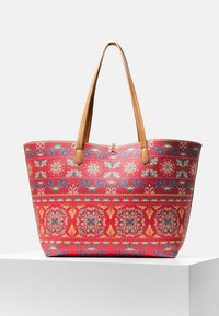 Bolso tote de color rojo con un diseño floral, que cuenta con asas de cuero marrón y una forma rectangular espaciosa. Se observa un detalle de superficie texturizada.