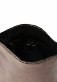 Borsa in pelle marrone con una superficie liscia, chiusura con zip e rivestimento interno nero, che mostra tasche interne e un design minimalista.