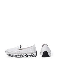 Bílé perforované slip-on boty s černou gumovou podrážkou, které mají grafický design a logo akcenty na podrážce a patě.