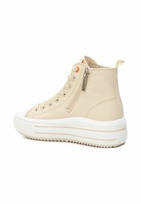 Zapatillas altas beige de lona con suelas de goma blanca, que cuentan con cremallera lateral, parte delantera con cordones y un sutil acento naranja.