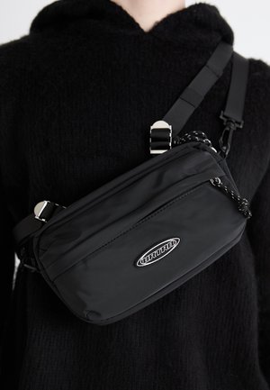 Zwarte nylon crossbody tas met een verstelbare schouderriem, met een gladde textuur, een voorzak met rits en een logo-accent.