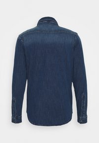 Dark blue denim shirt with long sleeves, buttoned cuffs, a rounded hem, and a classic collar design. Smooth texture with subtle fading.