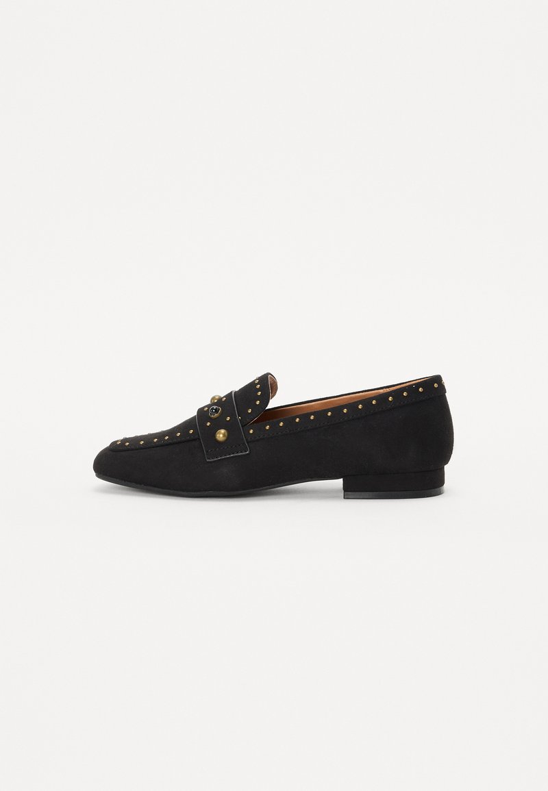 I mocassini in suede neri presentano una punta rotonda, una fascia decorativa con dettagli metallici e borchie lungo il bordo superiore. Tacco flat.