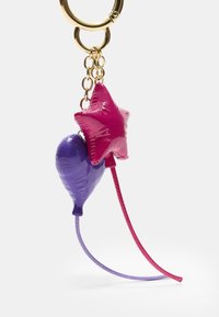 Porte-clés avec un ballon violet et une étoile rose, tous deux en matériau brillant ; comprend des cordes rouges et violettes fines et un anneau en métal doré.
