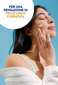 Crema su una guancia; il modello ha lunghi capelli scuri, indossa un top senza maniche di un delicato colore menta e un shawl bianco a trama. Lo sfondo �è blu.