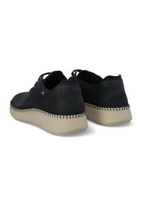 Scarpe in pelle scura con punta rotonda, suola in gomma beige e dettagli in cucitura attorno alla suola. Lacci e design a bassa apertura.