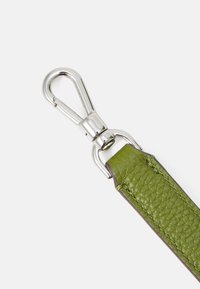 Pulseira de pele verde com uma superfície texturizada, apresentando componentes metálicos de cor prata e costura marrom ao longo das bordas.