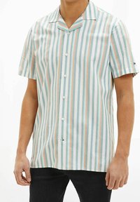 Koszula z krótkim rękawem w pionowe paski w kolorach jasnoniebieskim, zielonym i koralowym, z kołnierzem z wcięciem i białymi guzikami. Materiał mieszanka bawełny, o fakturowanej powierzchni.