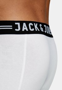 White cotton boxer briefs with a black elastic waistband featuring "JACK & JONES" in white lettering. Smooth texture, fitted design.