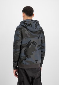 Sötét szürke kapucnis pulóver kék és fekete kamuflázs mintával. Bordás mandzsettákkal és szegéllyel, puha anyagból készült.