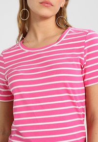 Pink striped t-shirt with white horizontal stripes, soft fabric, crew neckline, and short sleeves, showcasing a casual design.