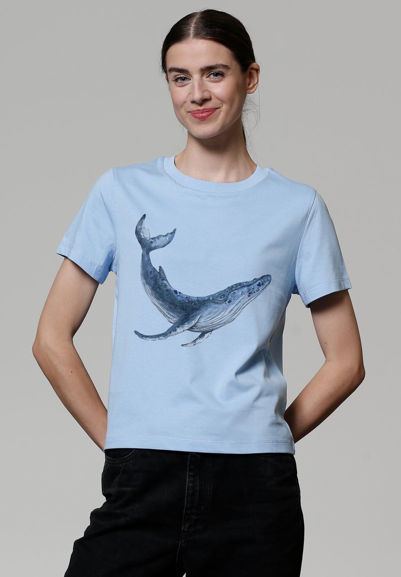 Lichtblauwe katoenen T-shirt met een gedetailleerde walvissendruk in verschillende tinten blauw en grijs, met korte mouwen en een ronde hals.