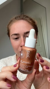 Bottiglia dropper in vetro marrone con cappuccio dropper bianco, etichettata "Pai The Impossible Glow." Contiene gocce abbronzanti per pelli sensibili.
