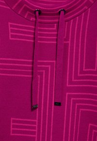 Felpa fucsia con un pattern geometrico testurizzato, caratterizzata da un colletto a coste e lacci coordinati. Piccolo logo nero come accentuazione.