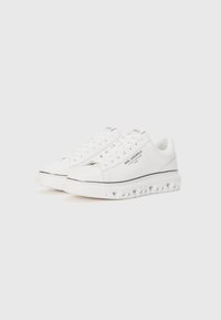 Witte leren sneakers met een gestructureerde zool, voorzien van zwarte accenten en logo-details. Klassiek vetersluiting ontwerp met een gevoerde kraag.