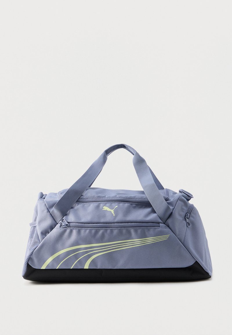 Lyse lilla Puma rejsetaske med to håndtag, lynlåslommer, gult logo og buet stribedesign på hvid baggrund.