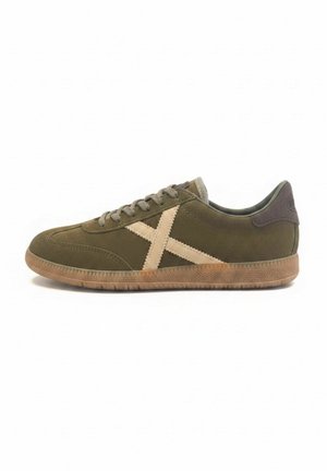 Sneaker bassa in pelle scamosciata verde oliva con dettaglio beige a croce sul lato, lacci marroni e suola in gomma.
