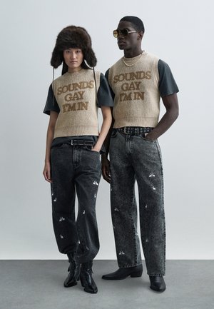 Divi modeļi valkā saskaņotas drēbes: bēša austs veste ar uzrakstu "SOUNDS GAY I'M IN" un melnas džinsa bikses ar zaķu rakstiem. Aksesuāru komplektā ir kažokādas cepure un saulesbrilles.