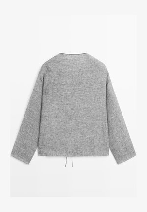 Chemise en lin grise à manches longues avec un ourlet droit et deux petits cordons suspendus à l'arrière, au bas.