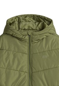 Chaqueta aislante verde oliva con capucha, con costuras horizontales, cremallera completa y un pequeño logo bordado. Textura suave.