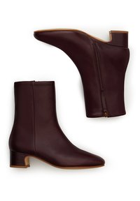 Burgundowe skórzane botki za kostkę z ostrym noskiem, średniej wysokości obcasem w kształcie bloku oraz z zamkiem błyskawicznym z boku. Gładka faktura i elegancki design.
