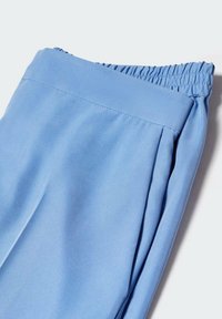Lichtblauwe stoffen broek met een elastische tailleband en een zachte textuur, voorzien van geplooide details aan de voorkant voor een casual pasvorm.