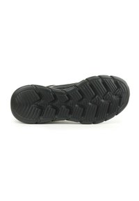 Suola di scarpa sportiva nera con un motivo ondulato e una trama segmentata per una migliore aderenza. Il materiale sembra gomma con una finitura liscia.