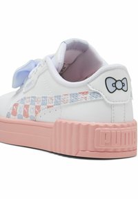 Zapatilla blanca con un patrón a cuadros en rosa y azul claro, adornada con iconos de dibujos animados en los lados, finalizada con una suela texturizada en rosa y un acento de lazo.