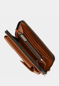 Brown leather wallet with a zip closure, multiple card slots, and a zippered compartment. Features a sleek design and contrasting black zipper.