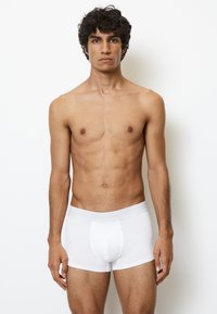 Hvide bomulds boxershorts med et tætsiddende design og en blød elastisk talje med et subtilt logo. Glat tekstur, længde til midt på låret.