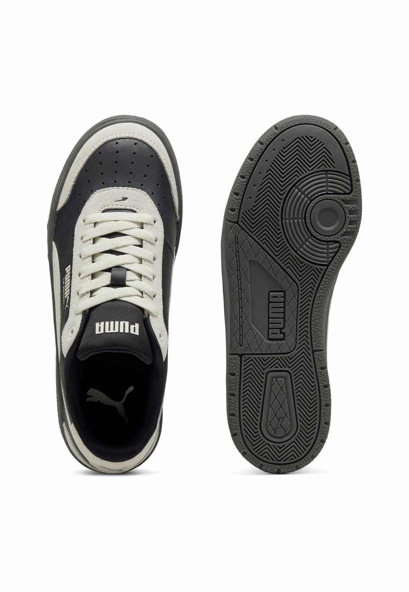 Czarno-kremowe sneakersy z cholewką z skóry i tekstyliów, z perforowanym wzorem, białymi sznurówkami oraz teksturowaną czarną gumową podeszwą.