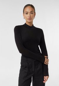 Zwarte lange mouwen turtleneck top in een getailleerd ontwerp, gemaakt van zachte, rekbare stof; heeft verlengde mouwen met duimgaten.