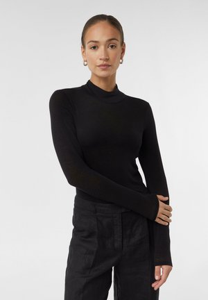 Zwarte lange mouwen turtleneck top in een getailleerd ontwerp, gemaakt van zachte, rekbare stof; heeft verlengde mouwen met duimgaten.