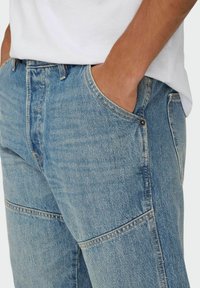 Lysblå denimjeans med en regular fit, synlig syning, traditionelle lommer og en subtil vasket tekstur. Detalje med frontklips til stede.