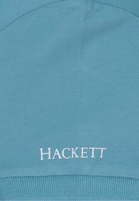 Tyrkysová pletená čepice s texturovaným povrchem. Na přední straně se nachází bílé vyšívané logo "HACKETT". Klasický design s přiléhavým tvarem.
