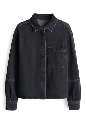 Chemise noire en denim à manches longues avec col, poche poitrine simple sur la gauche, boutons frontaux dissimulés par un rabat, et coutures sur les manches et les épaules.