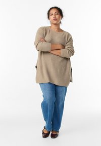 Beež tekstuuriga kootud kampsun pikkade varrukatega, mida on kombineeritud helesiniste teksade ja burgundia punaste baleriinidega. Kampsunil on küljealused lõhikud.