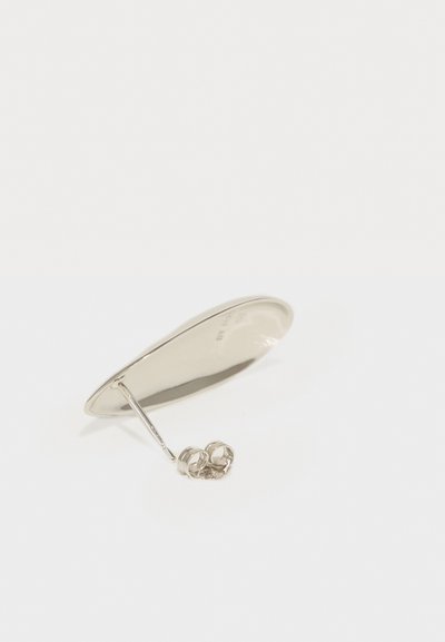 Srebrna uho kvačica s gladkim, izduženim dizajnom uz tanku podlogu i kružnim detaljem na bazi, koji odražava svjetlost i teksturu.