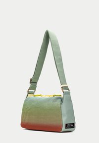 Borsa piccola con design a gradiente; parte superiore in rete teal, parte inferiore arancione. Presenta una tracolla verde, chiusura lampo gialla e etichetta del marchio.