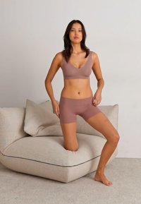 Rosenfarbene BH- und Short-Set aus weichem Stoff; der BH hat ein V-Ausschnitt-Design und nahtlose Verarbeitung, die einen glatten Sitz bietet.