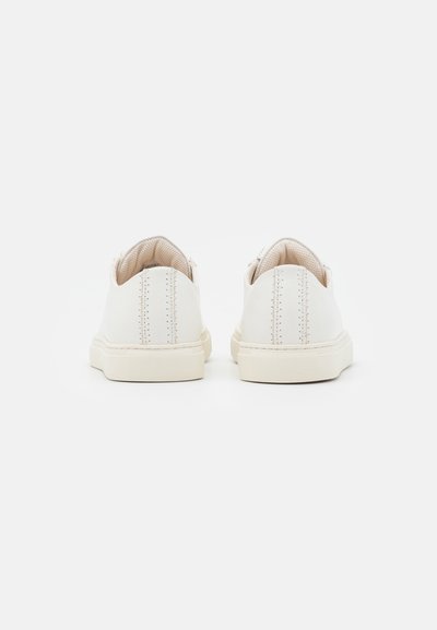 White leather sneakers with a smooth finish, rounded toe, and textured beige rubber sole. Features subtle stitching details at the back.