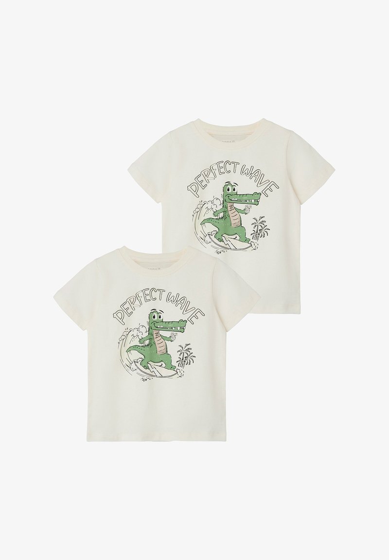Organic cotton t-shirts in cream with a green crocodile graphic surfing, text "PERFECT WAVE," round neck, short sleeves, and relaxed fit.
