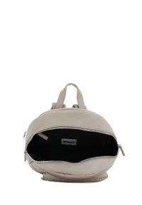 Zaino in pelle beige con forma arrotondata, due manici superiori e chiusura con zip. Interno nero con etichetta del marchio visibile.