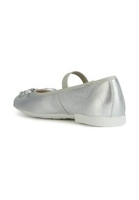 Bailarinas metálicas plateadas con parte superior texturizada, tira elástica en el talón y un pequeño detalle de moño en la punta. Suela de goma blanca.