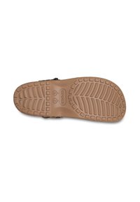 Suela de goma marrón de un zapato con patrones de relieve profundos. Incluye un logotipo en relieve y la información de talla cerca del talón.