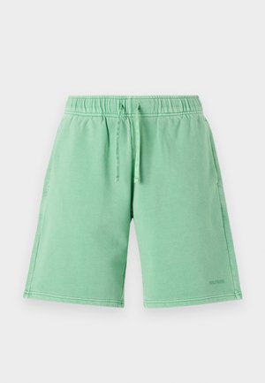 Grønne shorts laget av mykt stoff med elastisk midjebånd og snor. Designet inkluderer lommer og en logo på nederste del.
