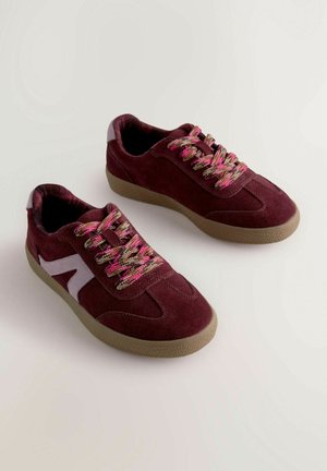 Bordeaux kleurige suède sneakers met een gestructureerde rubberen zool, voorzien van roze en bruine patroonveters en een lichtgrijze accent bij de hiel.